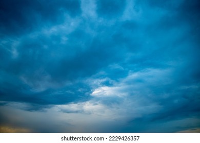 Sunset sky in bright blue tones. A wide panorama of the evening sky covered with dark clouds. Background with impending bad weather in anticipation of rain. - Shutterstock ID 2229426357
