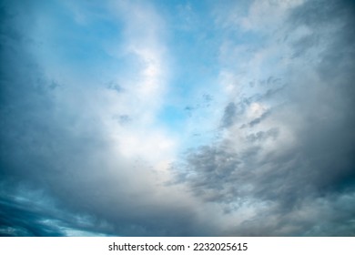 Sunset sky in bright blue tones. A wide panorama of the evening sky covered with dark clouds. Background with impending bad weather in anticipation of rain. - Shutterstock ID 2232025615