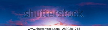 Sunset sky clouds featuring dramatic pink and purple clouds stretching across a dark blue panoramic sky with copy space