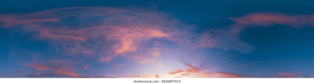 Sunset sky clouds featuring a panoramic view of colorful orange and purple cirrus wisps at dusk over a wide horizon