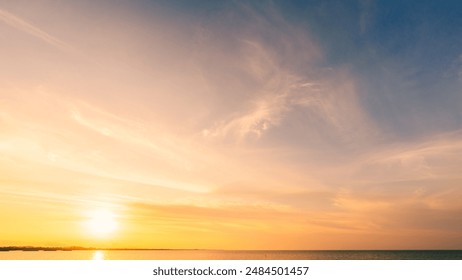 Sunset, Sky clouds over sea in the Evening with Orange, Yellow Gold sunlight in Golden hour and Dramatic fluffy, Horizon sea Summer sky landscape, Dusk sky background