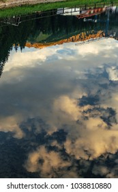 Sunset sky and clouds reflection in mountain lake