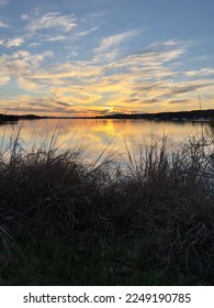 Sunset sky with clouds reflections on the golden lake.  Inks lake State Park is a part of the Texas Hill Country