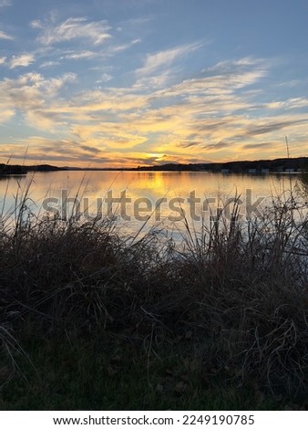 Sunset sky with clouds reflections on the golden lake.  Inks lake State Park is a part of the Texas Hill Country