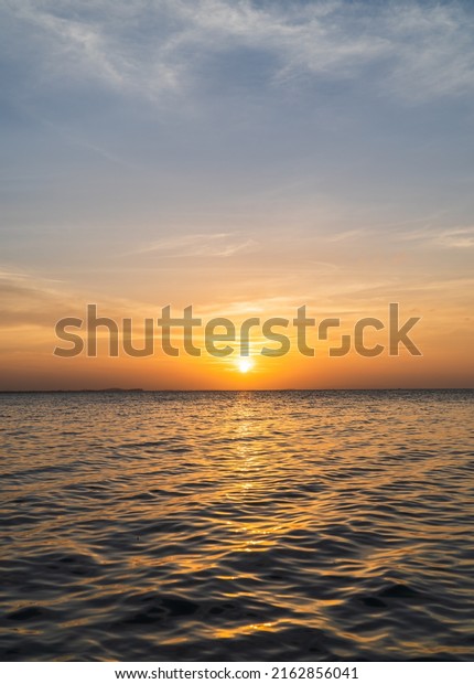 Sunset sky clouds vertical over sea in the\
evening with colorful orange sunlight reflect on the sea landscape\
with summer travel\
concept