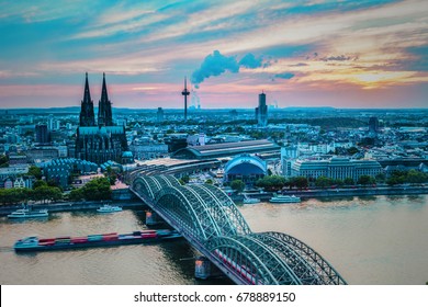sunset sky with colors and clouds over the city Cologne with Bridge and Köln Dom ,Evening scene over Cologne/Koln city with Kolner Dom/Cathedral behind the Hohenzollern bridge and Koln towers,
