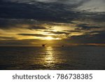 Sunset sky at deep sea with silhouette offshore platform on the background.