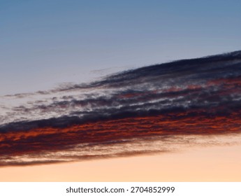 sunset sky with dramatic cloud bank streaked in crimson and indigo, landscape photographer framing wide