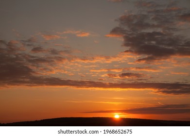 sunset sky fire clouds on mountain top. Beautiful sunset sky and clouds with dramatic light, Seascape twilight sky and sun rays on mountain, Orange and red sky background with light of the sun
