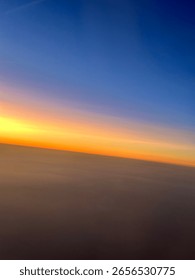 Sunset sky gradient seen from an airplane window blue, orange, and yellow colors blending softly