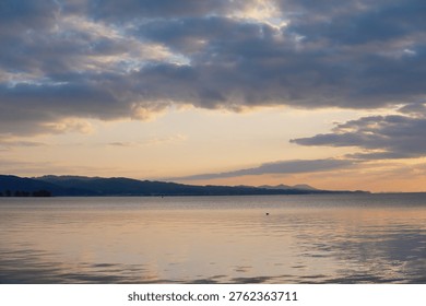 Sunset Sky and Mountain Range Reflected on the Serene Lake Surface