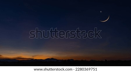 Sunset sky over mountain in the evening on twilight with crescent moon on dusk sky, religion of Islamic and free space text Ramadan Kareem, Eid Al Fitr, Eid Al Adha, Eid Mubarak 