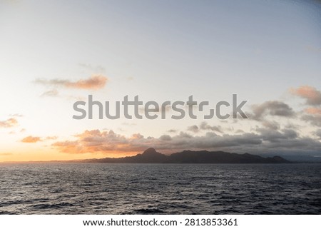 Sunset sky over the ocean with distant island silhouette, Kauai