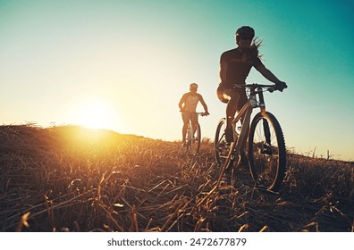 Sunset sky, people and friends on bicycle with exercise, race and adventure trail in nature together. Cycling, fitness and team with mountain bike in evening for outdoor workout, sun and countryside