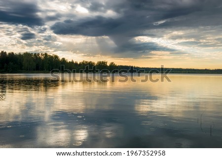 Sunset sky with rain cloud on the lake.