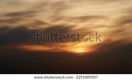 Sunset sky with red light of the setting sun, timelapse. Evening clouds in the orange light of sunset rays, time lapse