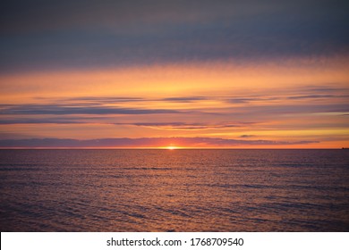 Sunset sky reflecting in the water, aerial view from the sandy shore. Setting sun. Abstract art, natural pattern. Baltic sea, Sweden. Idyllic seascape. Travel destinations, vacations concept - Powered by Shutterstock