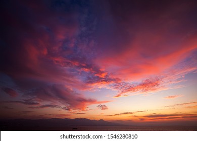 Sunset sky, sea and mountain view. Sunset colors on the clouds.