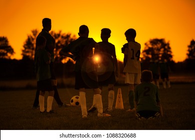 Sunset Soccer. Kids Soccer Football Team On Training With The Coach. Sports Soccer Practice At Sunset. Soccer Summer Camp For Sporty Children