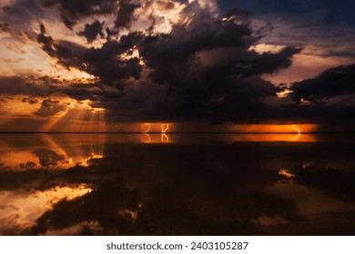 Sunset storm cloud sky dramatic weather ocean sea water reflection horizon landscape nature cloudscape. Dark orange light atmospheric moody dusk twilight seascape scenic. Thunder lightning rain heavy