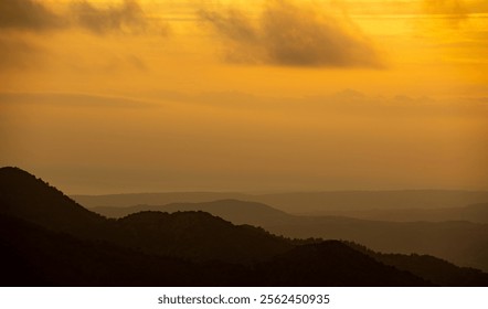 Sunset with stormy cloud sky and dramatic orange sunlight above mountain. Troodos mountains Cyprus