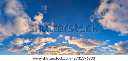 Sunset with sun and clouds on blue and orange dramatic sky with sun rays. A stroll along the forest shape silhouettes. Ultrawide color and light evening golden hours endless space and tranquility.
