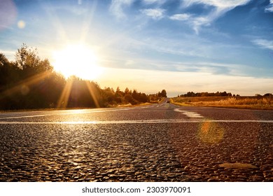 Sunset or sun Rising Above Asphalt Country Road In Sunny evening or Morning. Open empty Road In Summer Or Autumn Season. Concept of beautiful travel - Powered by Shutterstock