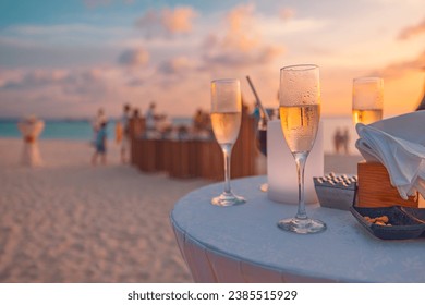 Sunset sunlight closeup glasses of champagne in a restaurant on the coast of a resort in the Maldives. Blurred people having fun at weekend summer night, leisure lifestyle. Outdoors bar beach view - Powered by Shutterstock