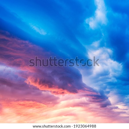 Sunset and sunrise against the beautiful clouds of red purple and pink with bright hot rays symbolize the beginning of a new day, good and peace
