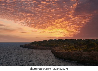 Sunset Or Sunrise On The Coast With Cliffs. Orange Sky With Clouds, No People