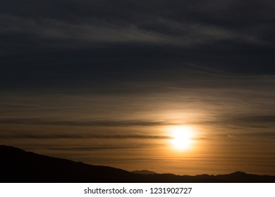 Sunset through the Clouds and Mountains