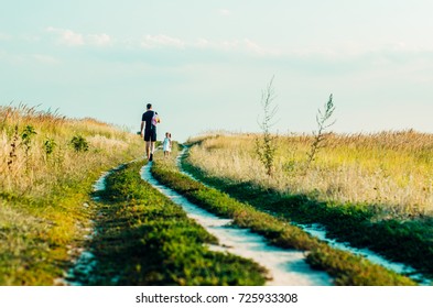 sunset time on the field. Golden spikelets , the flowers of the field. landscape autumn field at sunset . people walk on the nature. little girl playing with dad - Shutterstock ID 725933308