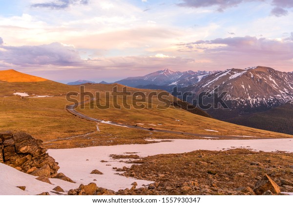 Sunset Trail Ridge Road - A Spring sunset view of\
Trail Ridge Road winding through alpine tundra at top of Rocky\
Mountains, with Longs Peak rising high in background, Rocky\
Mountain National Park,\
CO.