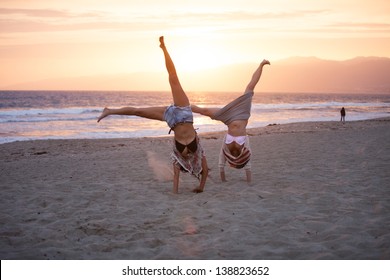 Sunset with Two Beautiful Woman doing cartwheels on the Beach in Santa Monica California - Powered by Shutterstock