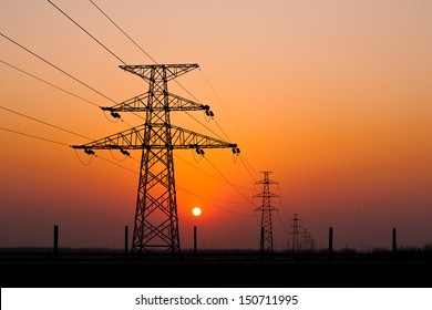 sunset under the high-voltage tower in the background