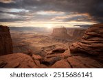 A sunset in Utah in Canyonlands National Park with clouds and red rock formations. 