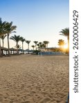 Sunset view of a beachside area with palm trees and a restaurant during the golden hour