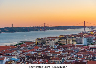 Sunset view of Bridge of 25th April and National sanctuary of Cristo Rei in Lisbon, Portugal