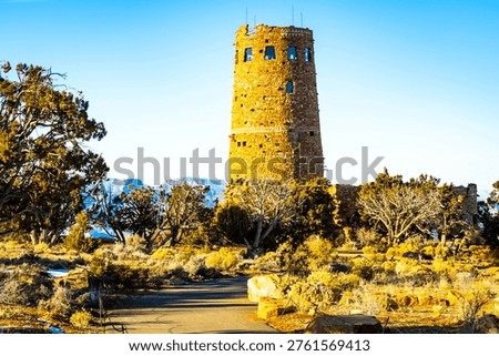 Sunset view of Desert View Watchtower overlooking canyon landscape with warm evening light
