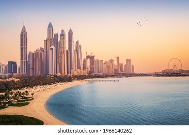 Sunset view of the Dubai Marina and JBR area and the famous Ferris Wheel and golden sand beaches in the Persian Gulf. Holidays and vacations in the UAE - Shutterstock ID 1966140262