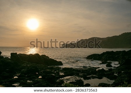 A sunset view featuring rock formations at Menganti Beach, Central Java.