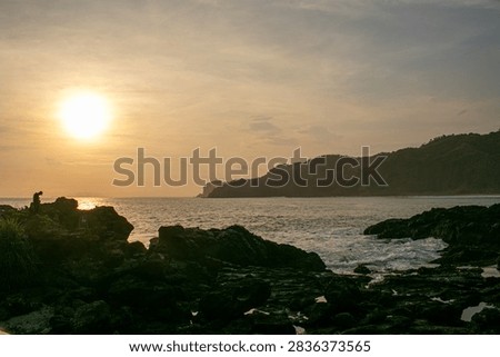 A sunset view featuring rock formations at Menganti Beach, Central Java.