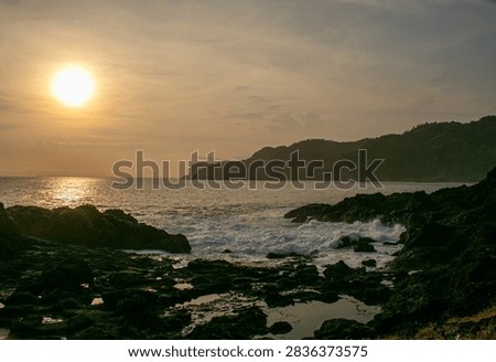 A sunset view featuring rock formations at Menganti Beach, Central Java.