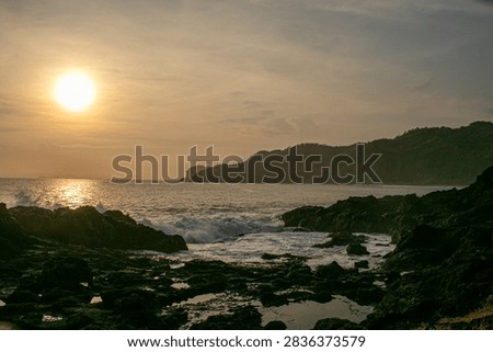 A sunset view featuring rock formations at Menganti Beach, Central Java.