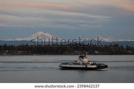 Sunset View of a Ferry Boat Crossing Hale Pass to Lummi Island. With Mt. Baker in the background this small ferry carries commuters who work in Bellingham, Washington. 