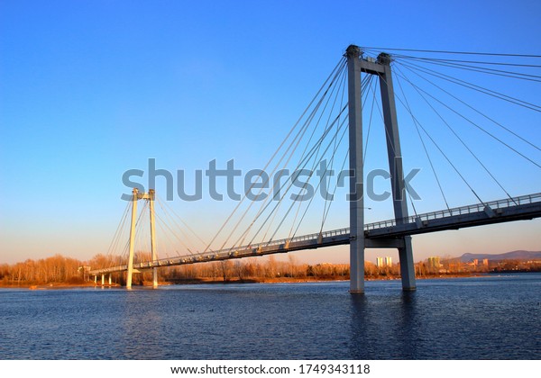 Sunset view of the foot Vinogradovsky cable-stayed
bridge through the Yenisei river on Tatyshev island in Krasnoyarsk,
Russia