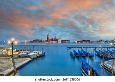 Sunset view of gondolas at St Mark's Square with the island of San Giorgio Maggiore behind , with its church front designed by Andrea Palladio and begun in 1566. Venice Italy.
