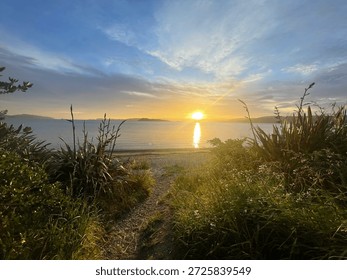 Sunset View From Grassy Beach Path Looking Across Sea And Distant Hills