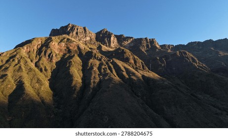 Sunset view of a mountain range slope during the golden hour. 