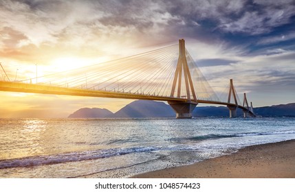 Sunset view on the bridge near Patras. Suspension bridge crossing Corinth Gulf strait, Greece, Europe. Second longest cable-stayed bridge in the world. Dramatic red sky under a Rion-Antirion Bridge. 